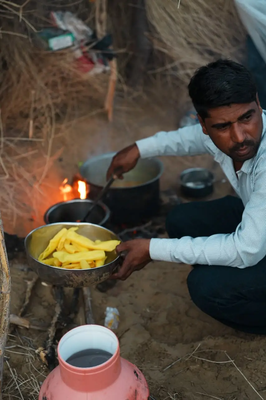 Cook preparing a traditional dinner over a fire in the desert